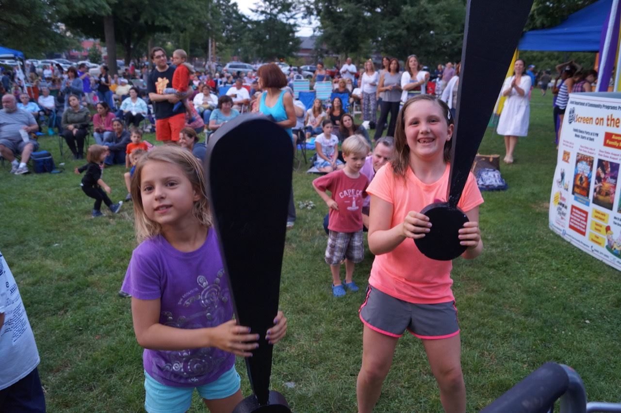 Two little girls hold the Share the Fun exclamation points.